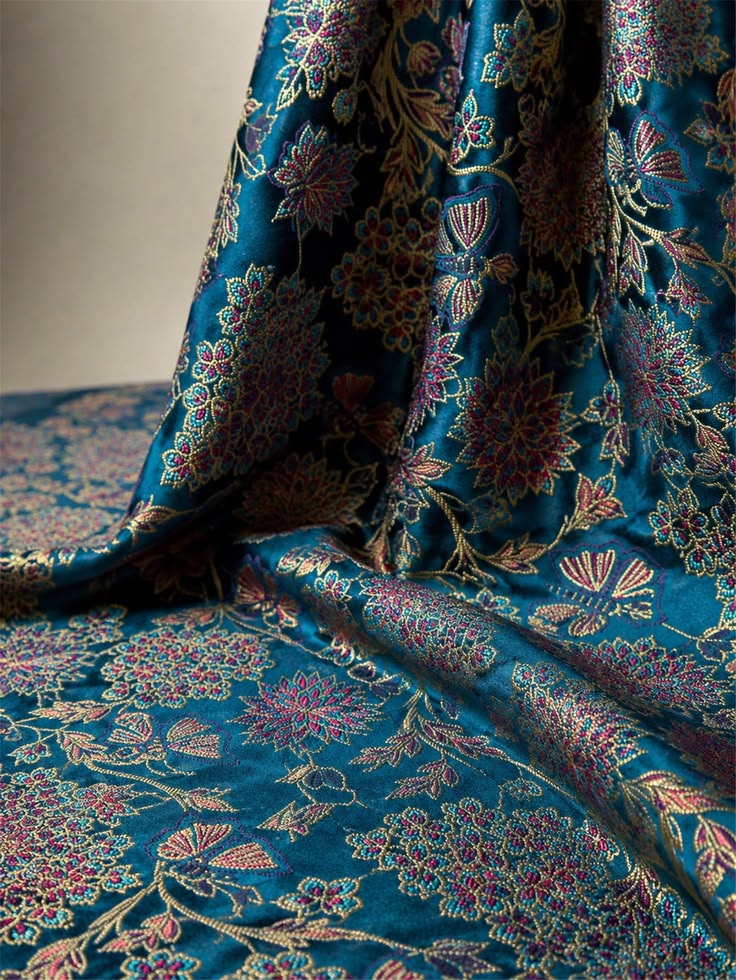Teal brocade fabric with intricate floral patterns
